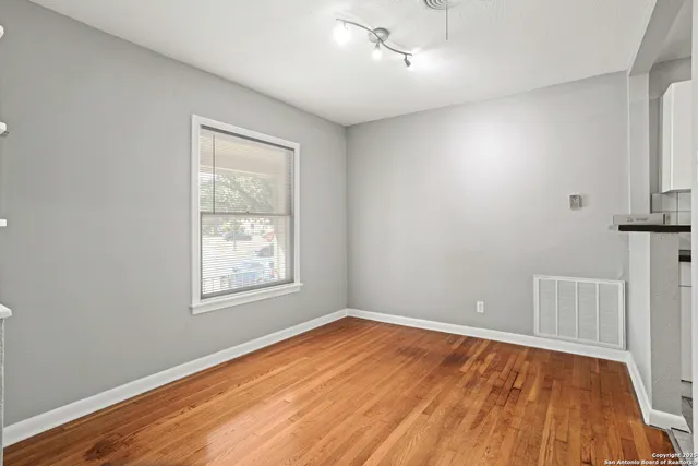 wooden floor in an empty room with a window