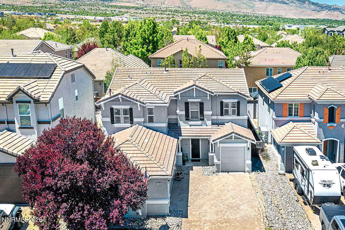 11365 Torino Way Reno, NV 89521 - Photo 3 of 29 a view of a white house next to a yard with plants and trees