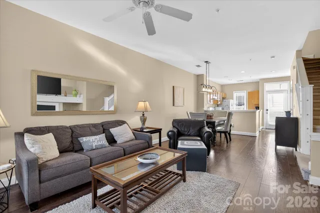 a living room with furniture a wooden floor and a chandelier