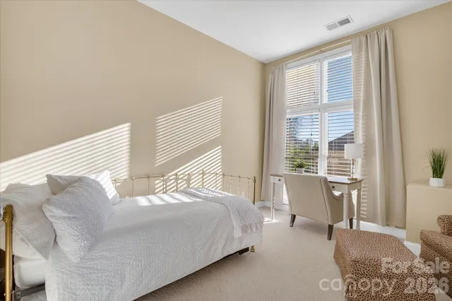 a bedroom with a large bed and wooden floor