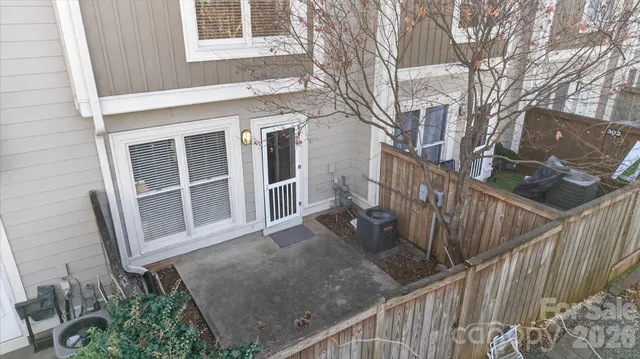 a view of a house with wooden fence in front of it