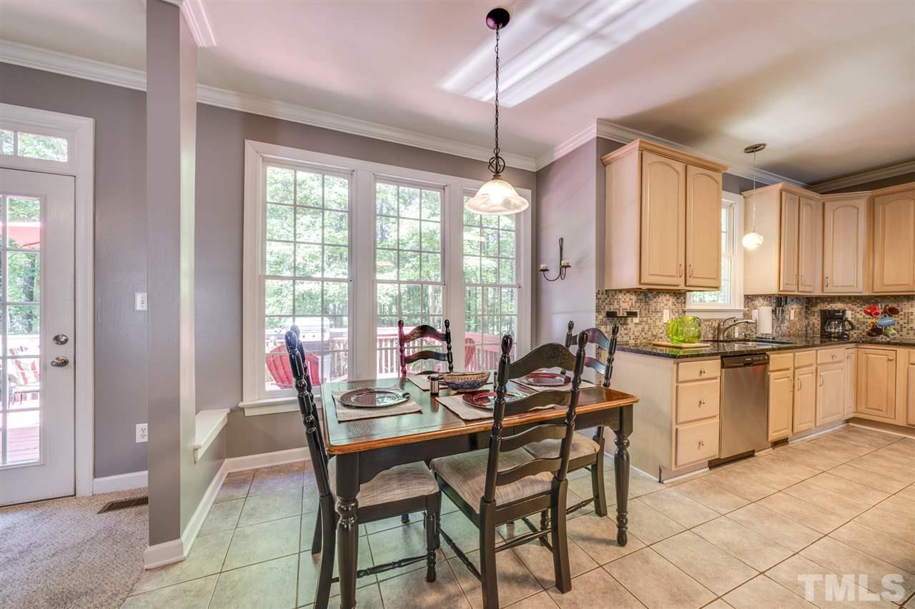 11921 Larka Court Raleigh, NC 27613 - Photo 5 of 30 a kitchen with a dining table chairs and granite counter tops