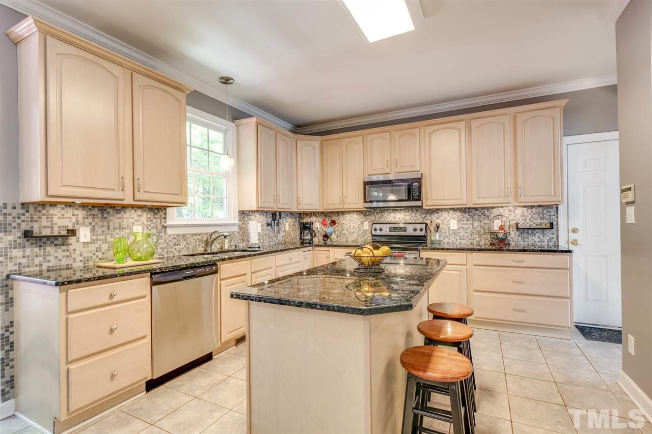 11921 Larka Court Raleigh, NC 27613 - Photo 8 of 30 a kitchen with stainless steel appliances granite countertop a stove a sink dishwasher and a refrigerator with wooden cabinets
