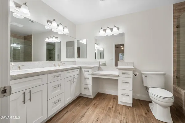 a spacious bathroom with a toilet sink double vanity and mirror