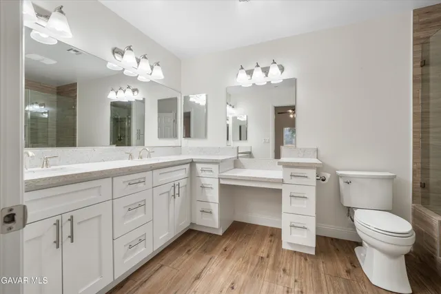 a spacious bathroom with a toilet sink double vanity and mirror