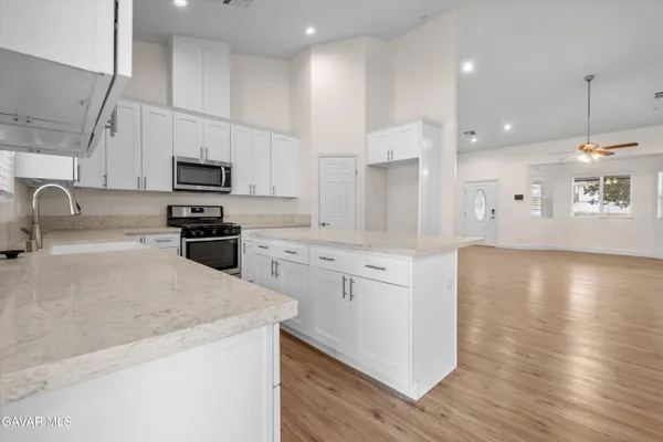a kitchen with kitchen island a sink appliances and cabinets