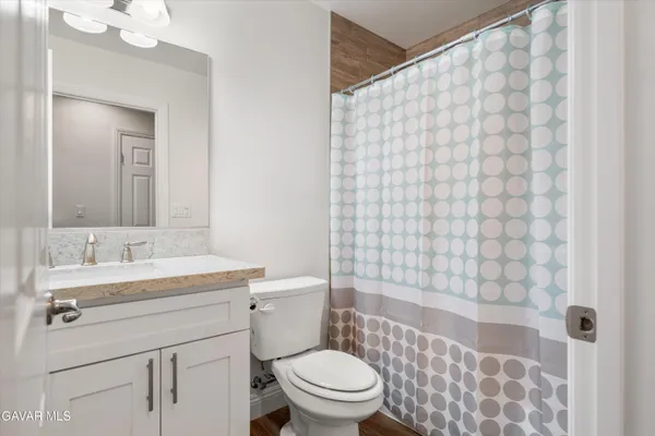 a bathroom with a sink a toilet and shower curtain
