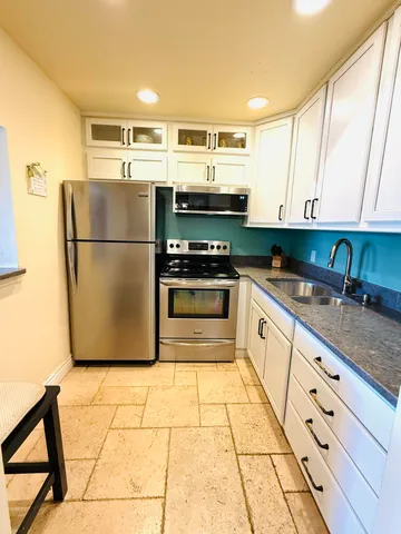 a kitchen with a sink a stove and a refrigerator