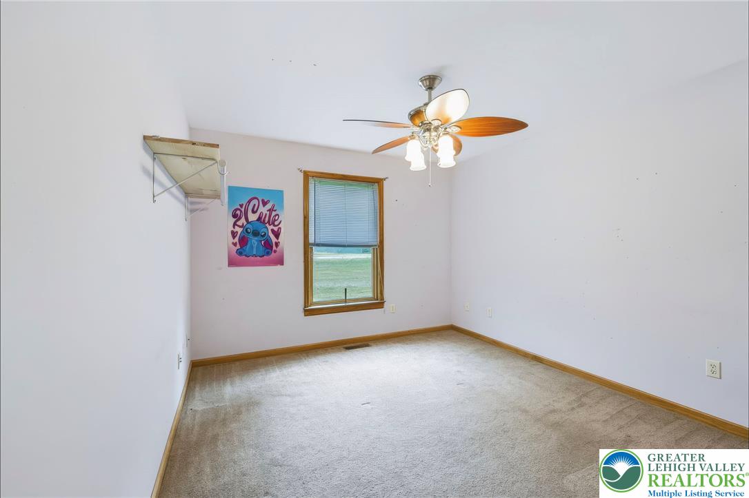 6970 Silver Crest Road Nazareth, PA 18064 - Photo 24 of 35 A well-lit bedroom features plush carpeting and a convenient ceiling fan for comfort.