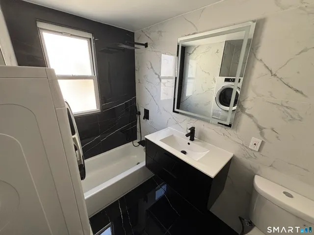 a bathroom with a sink a toilet a mirror and shower