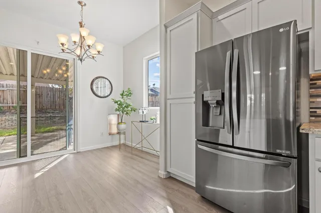 a kitchen with a sink dishwasher a stove a dining table and chairs with wooden floor