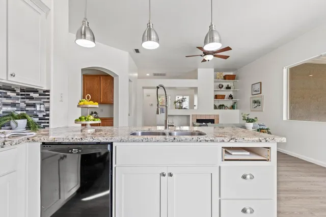 a view of a livingroom with wooden floor and a kitchen
