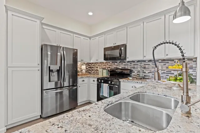 a kitchen with refrigerator a sink and a microwave