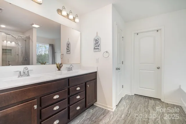 a spacious bathroom with a granite countertop sink a mirror and a shower
