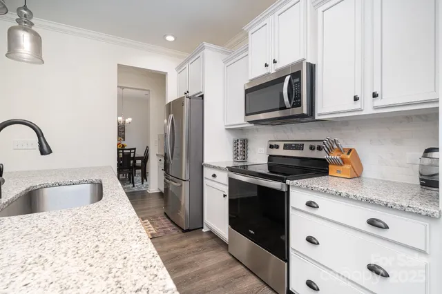 a kitchen with stainless steel appliances granite countertop a sink stove and refrigerator