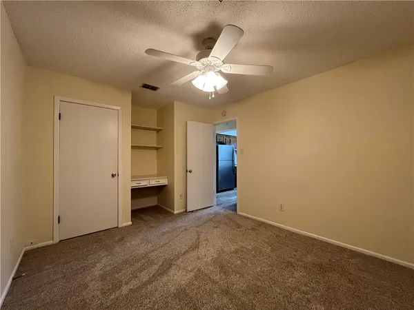 a view of an empty room and a ceiling fan