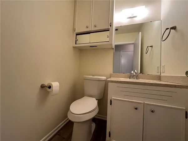 a bathroom with a toilet a sink and mirror