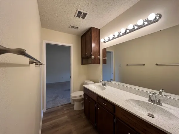 a bathroom with a double vanity sink mirror and toilet