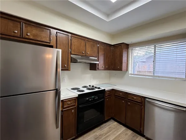 a kitchen with stainless steel appliances granite countertop a refrigerator a sink and a stove