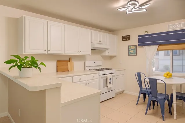 a kitchen with stainless steel appliances granite countertop a white cabinets and a stove top oven