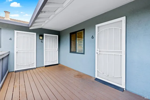 an empty room with wooden floor & windows