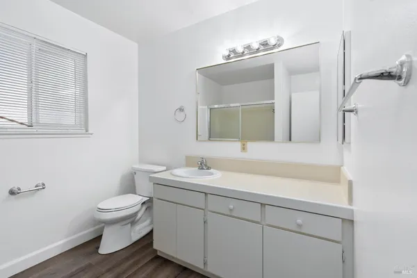 a bathroom with a toilet a sink and mirror