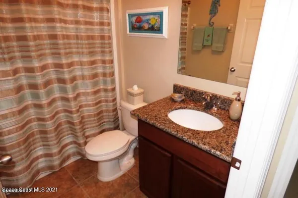 a bathroom with a granite countertop toilet and a sink