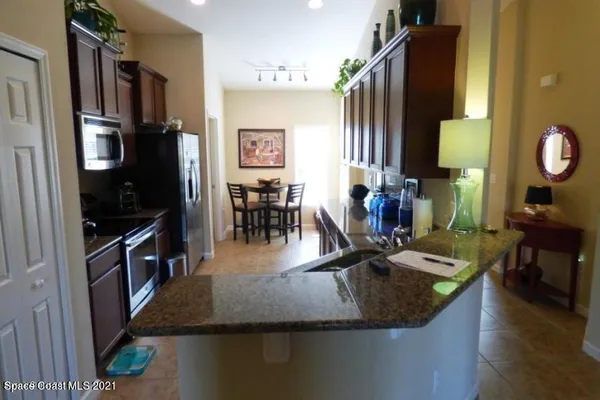 a kitchen with stainless steel appliances granite countertop sink stove top oven and cabinets