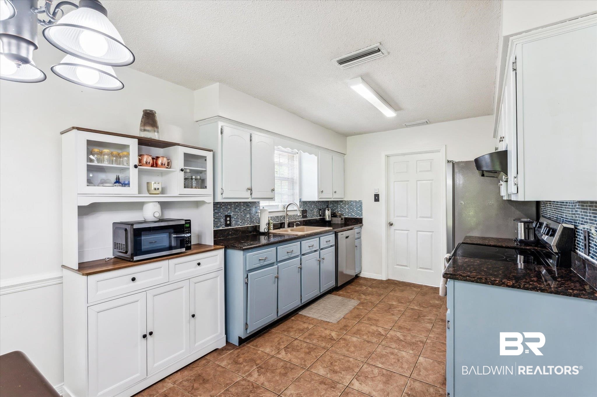 9306 Prairie Drive Semmes, AL 36575 - Photo 5 of 20 Kitchen featuring light tile patterned floors, an inviting chandelier, stainless steel appliances, decorative backsplash, and sink