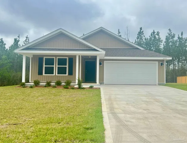 front view of a house with a yard and potted plants