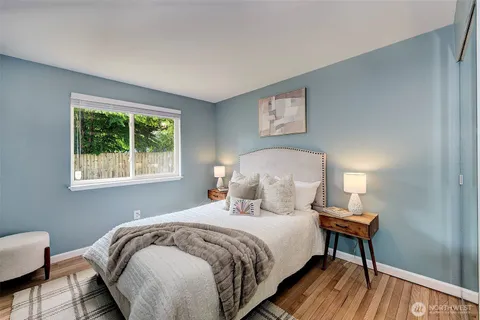 a bedroom with a bed two lamps with a window
