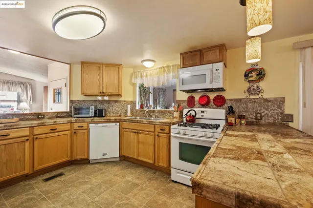 a kitchen with stainless steel appliances granite countertop a stove a sink and a refrigerator