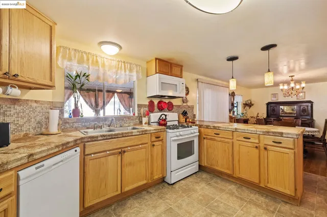 a kitchen with stainless steel appliances granite countertop a sink stove and cabinets