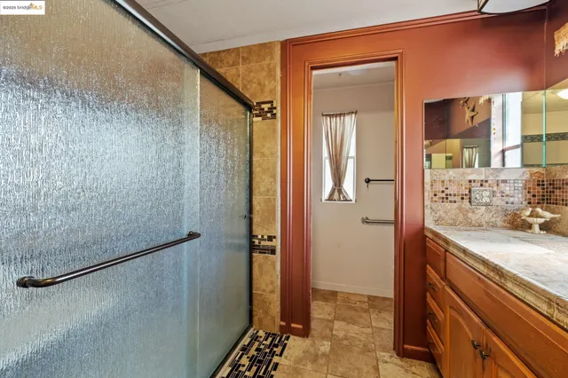 a bathroom with a granite countertop shower and a sink