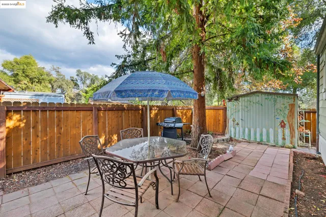 a backyard of a house with table and chairs