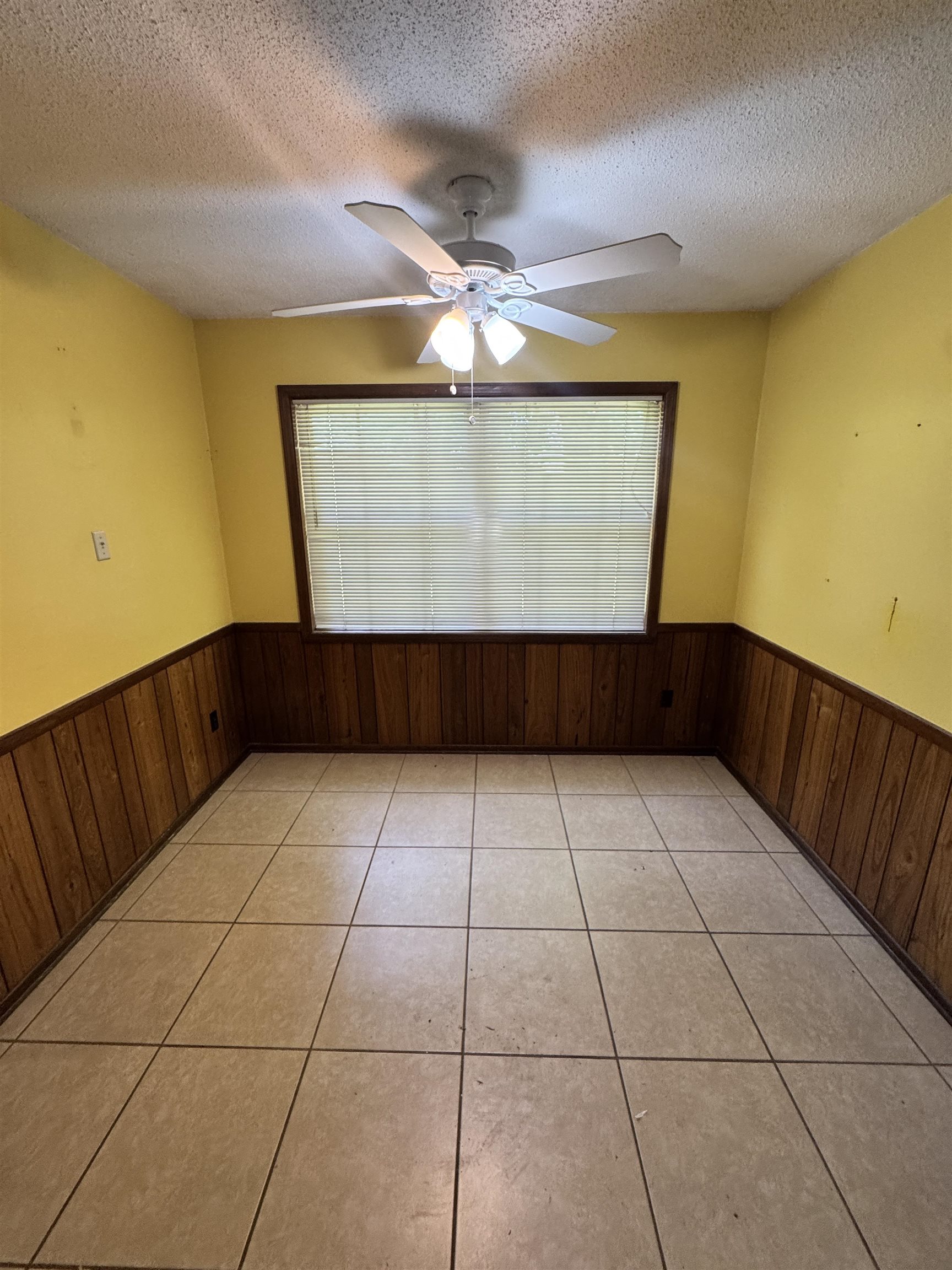 5520 Wagon Rd Gap, Unit GAP Memphis, TN 38134 - Photo 8 of 19 Spacious interior featuring tile flooring, wood paneling, a ceiling fan with integrated lighting, and a large window with blinds