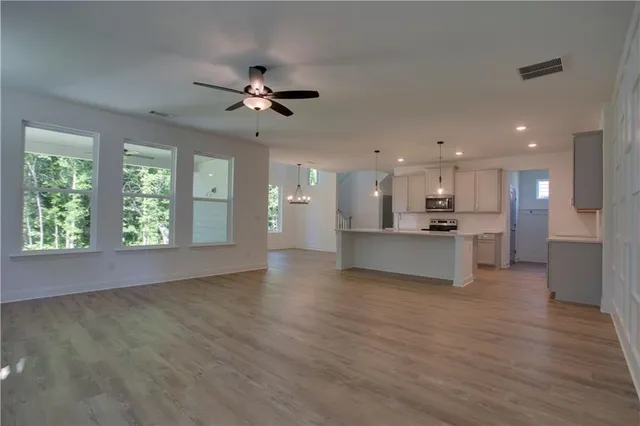 a large kitchen with a white stove top oven and white cabinets