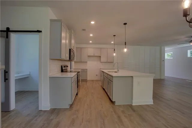 a kitchen with kitchen island a sink stainless steel appliances and cabinets