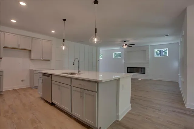 a kitchen with cabinets stainless steel appliances and wooden floor