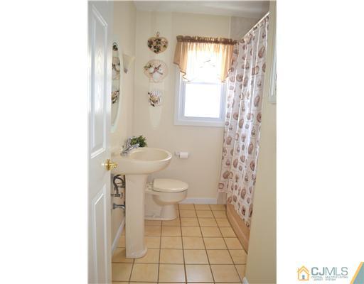 9 Dorian Road Metuchen, NJ 08840 - Photo 14 of 25 a bathroom with a sink a toilet and shower