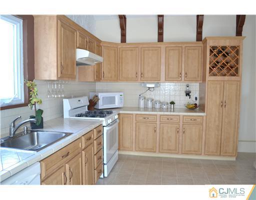 9 Dorian Road Metuchen, NJ 08840 - Photo 8 of 25 a kitchen with stainless steel appliances granite countertop a sink stove and cabinets