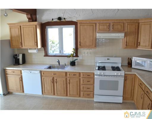 9 Dorian Road Metuchen, NJ 08840 - Photo 9 of 25 a kitchen with a stove top oven sink and cabinets