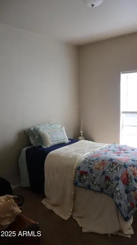 a bedroom with a bed lamp and a window