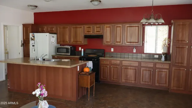 a kitchen with stainless steel appliances granite countertop a sink dishwasher and a refrigerator