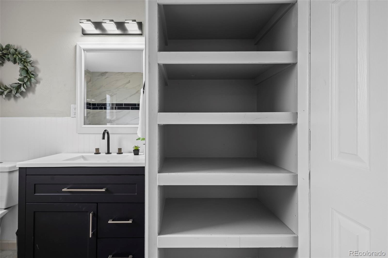 390 Scranton Street Aurora, CO 80011 - Photo 23 of 45 a bathroom with a sink and a mirror