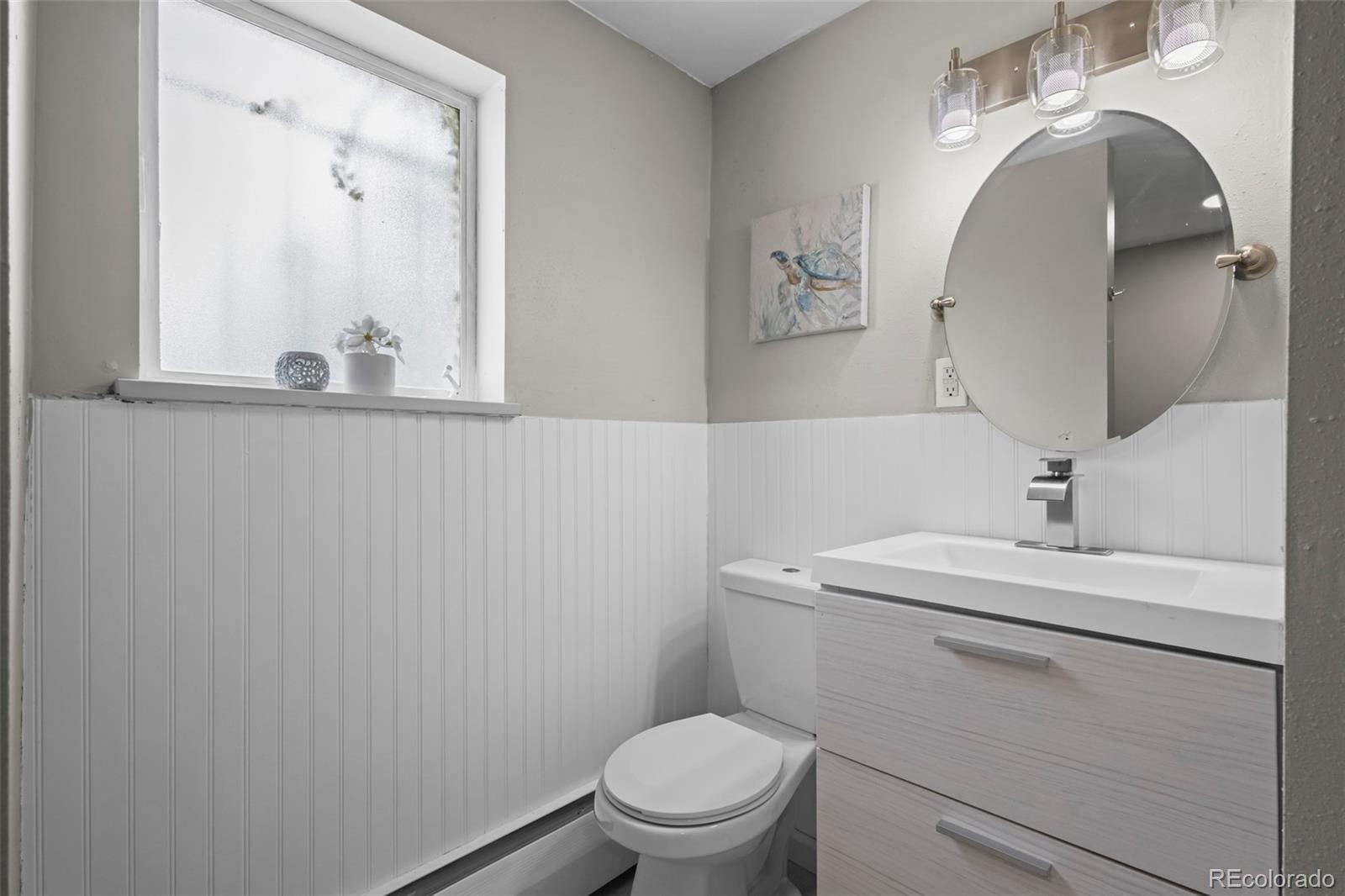 390 Scranton Street Aurora, CO 80011 - Photo 26 of 45 a bathroom with a toilet sink and mirror
