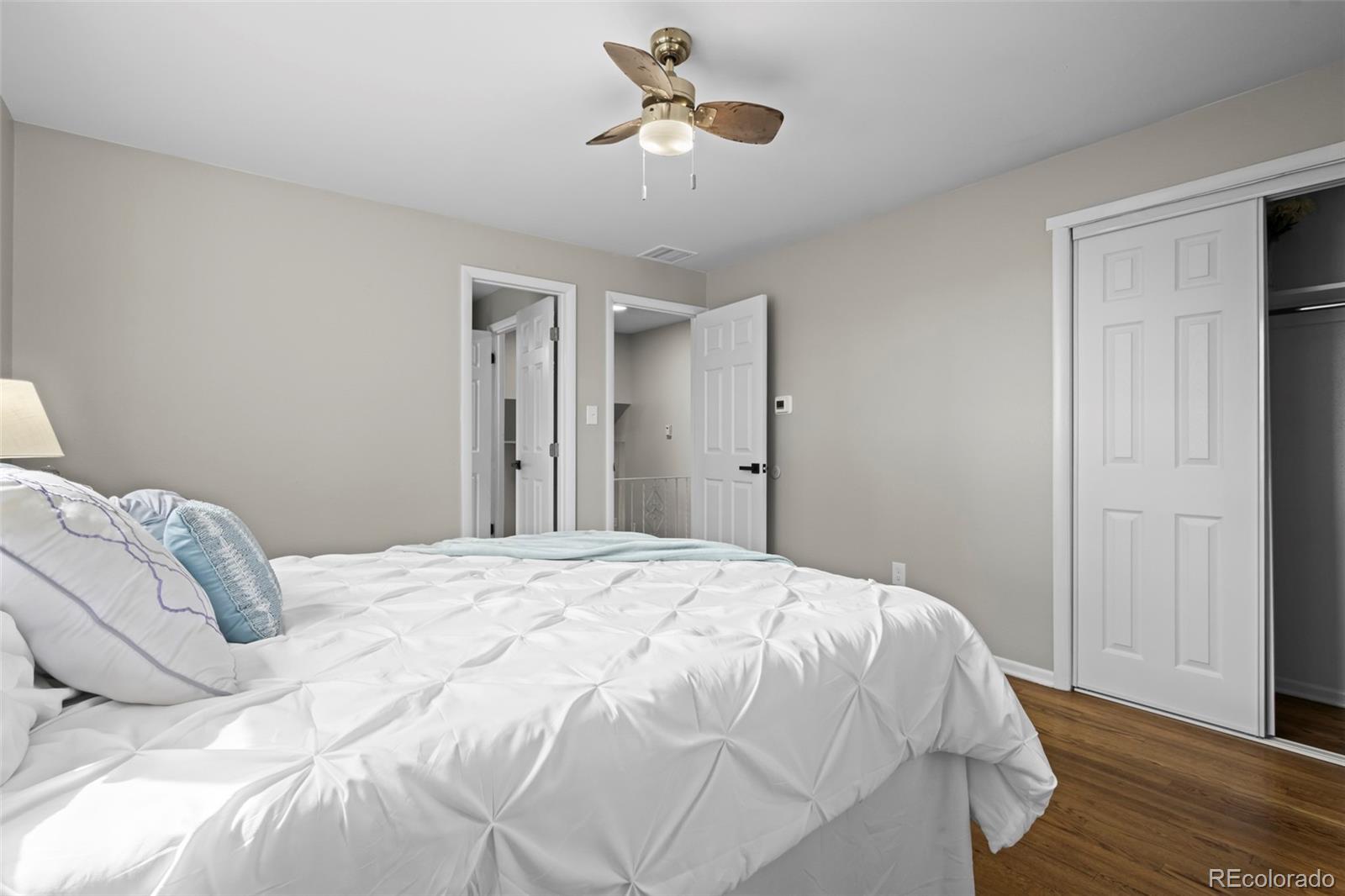 390 Scranton Street Aurora, CO 80011 - Photo 35 of 45 a bedroom with a bed and a chandelier