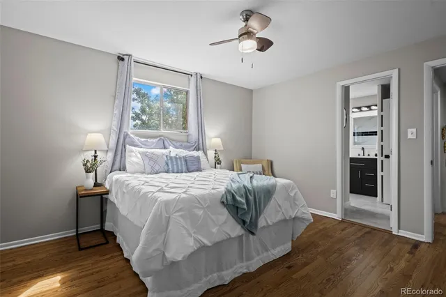 a bedroom with a large bed and wooden floor