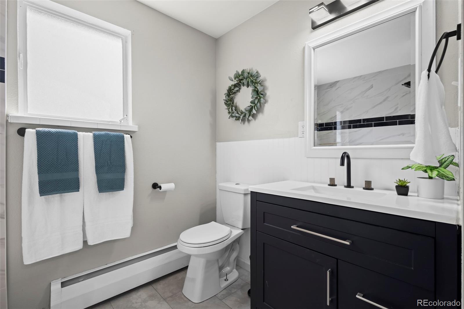 390 Scranton Street Aurora, CO 80011 - Photo 38 of 45 a bathroom with a toilet sink and mirror