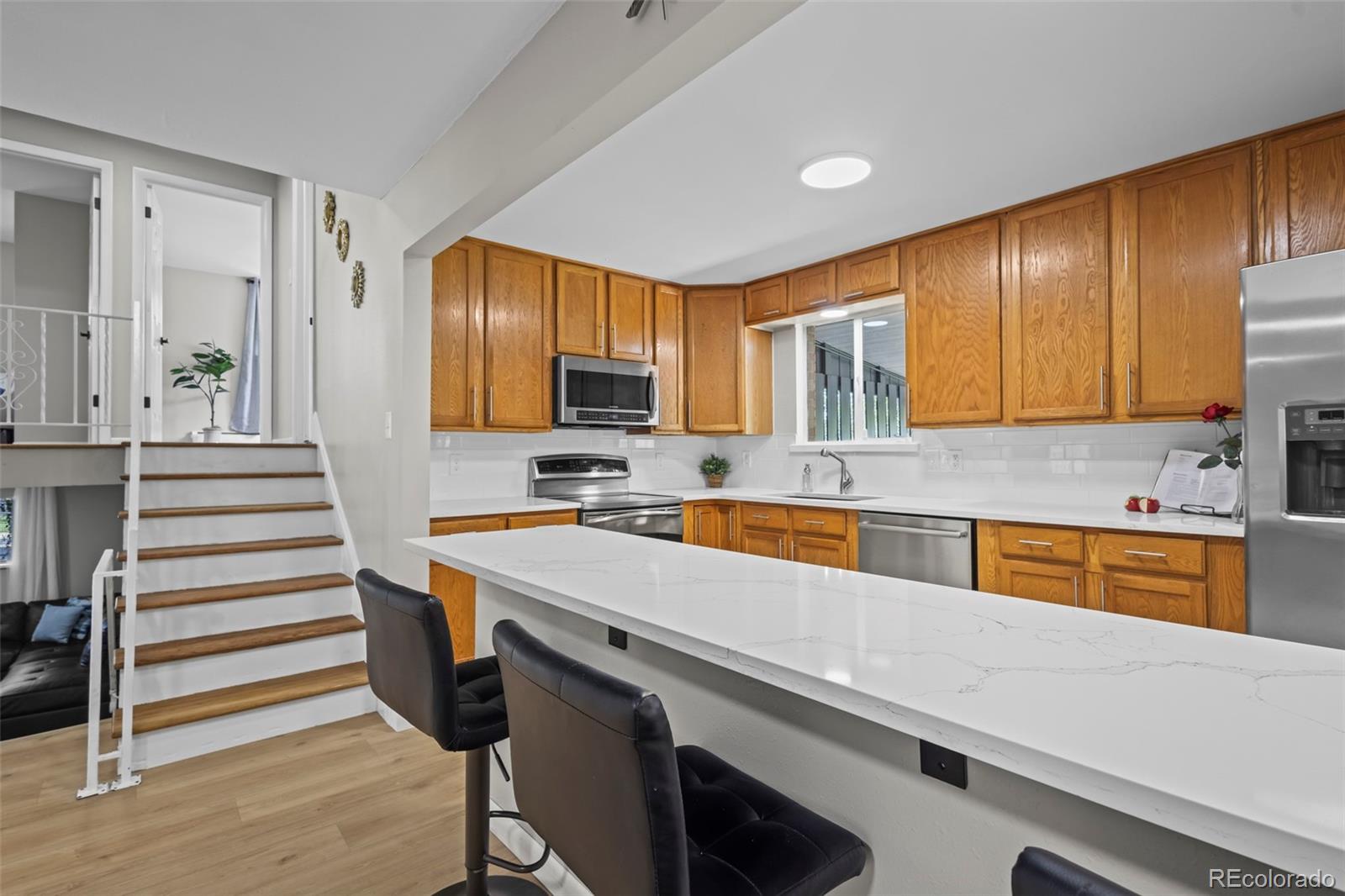 390 Scranton Street Aurora, CO 80011 - Photo 42 of 45 a kitchen with a refrigerator stove and sink
